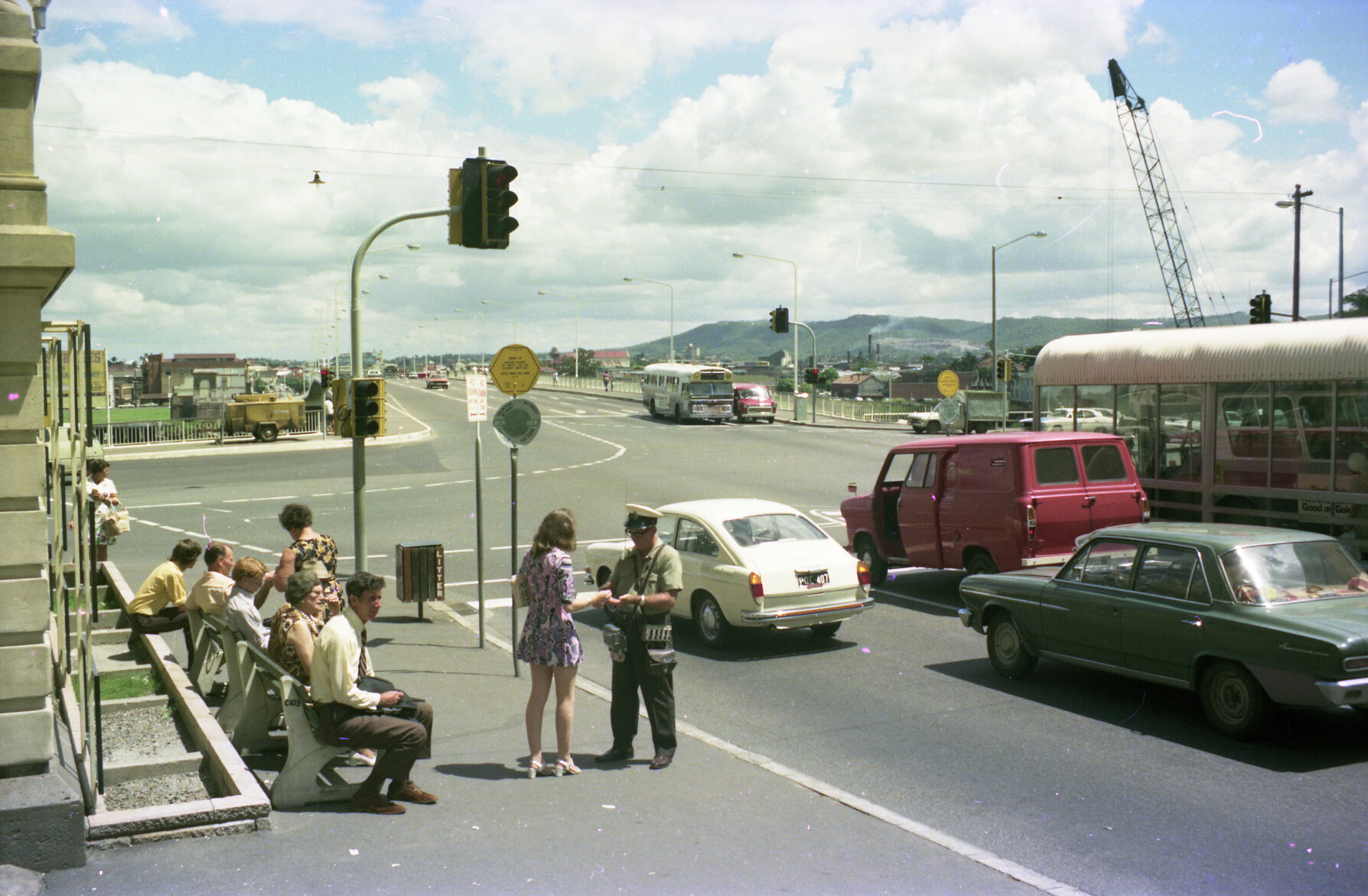 Bus conductor taking fare at Queen Street bus stop in front of Treasury Building, Brisbane City - 1975