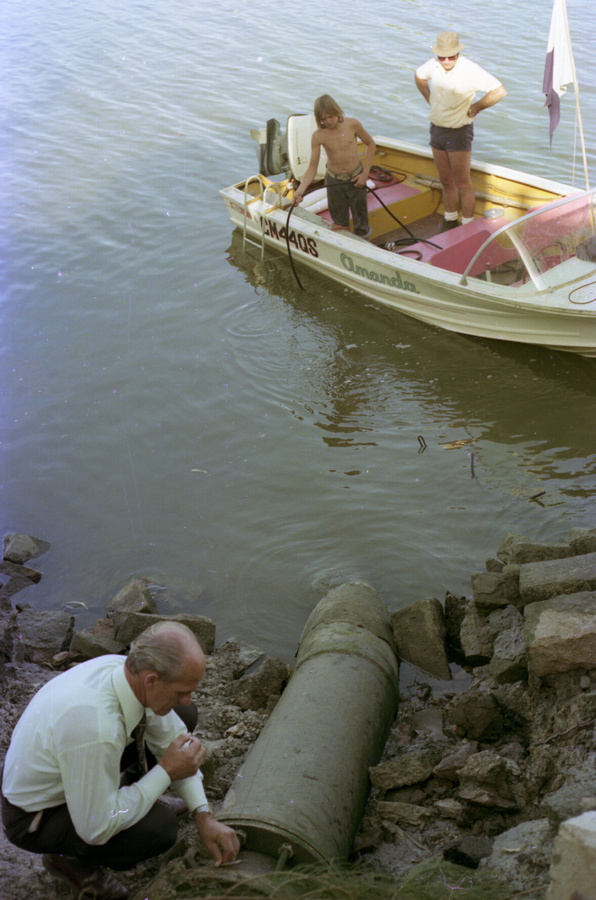 Council engineer inspects water pipe on Milton Reach with onlookers, Milton - 1975