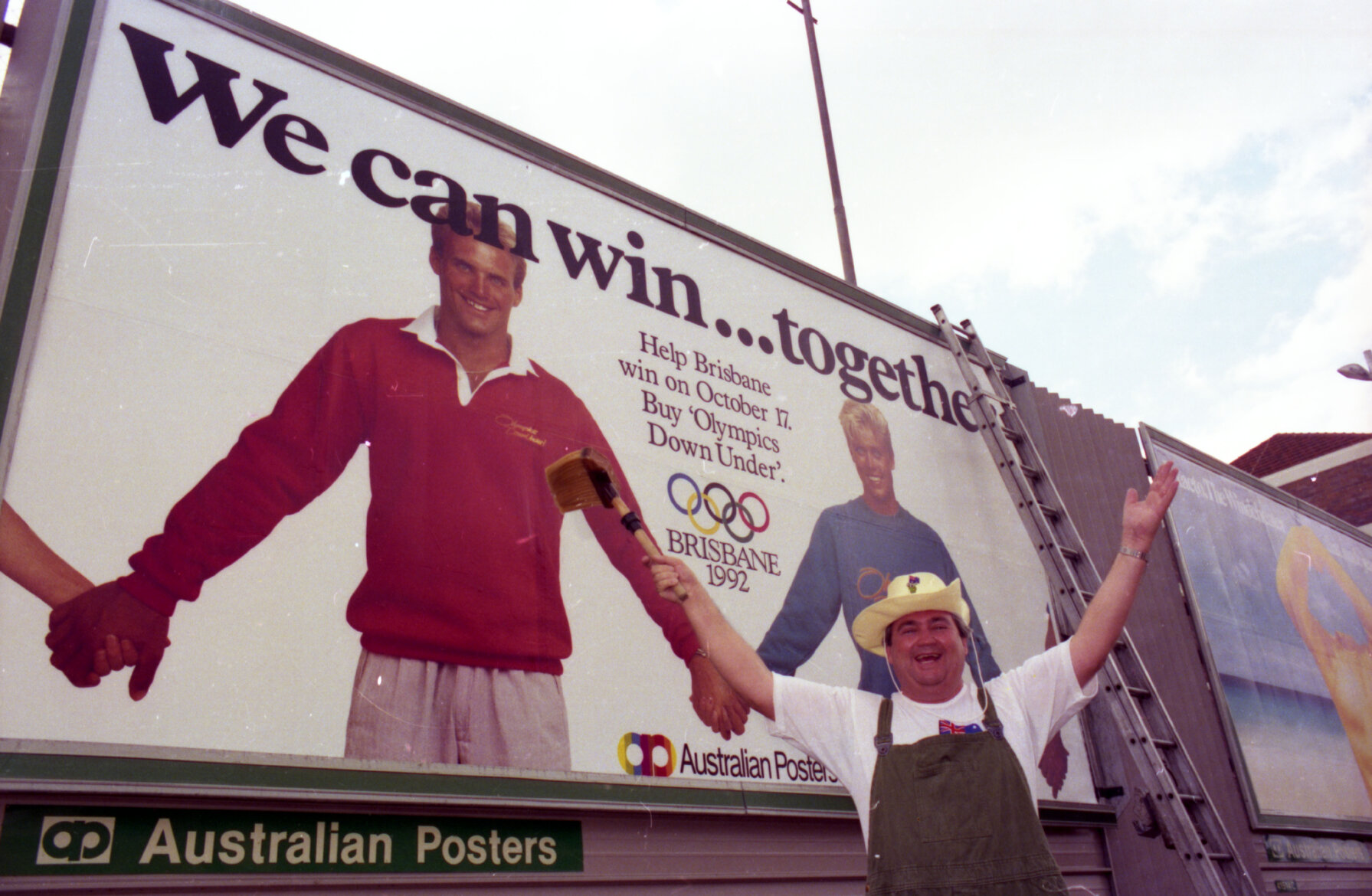 Billy J Smith by a billboard supporting Brisbane's bid for the 1992 Olympics, Fortitude Valley - 1986