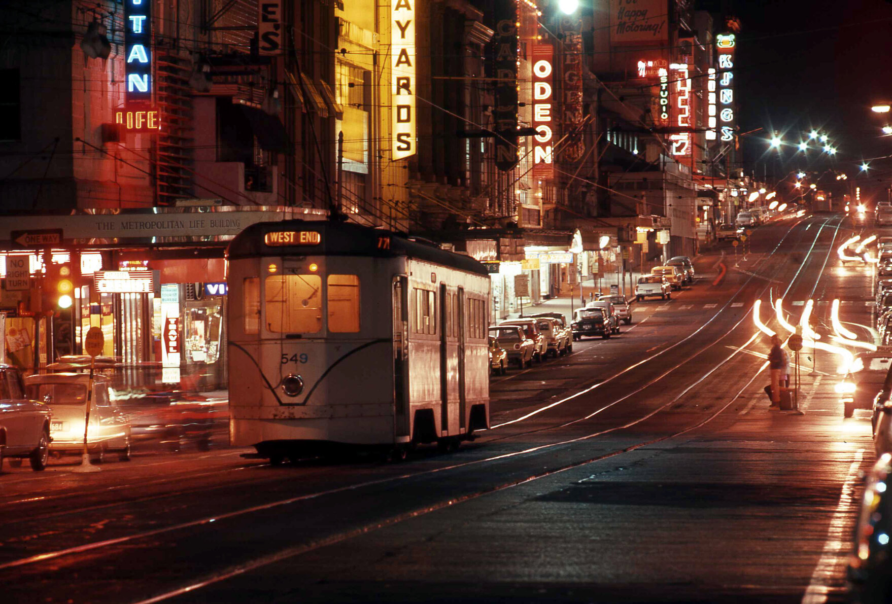 Tram No. 549 on Queen Street from Edward Street lit up with neon signs - 1969