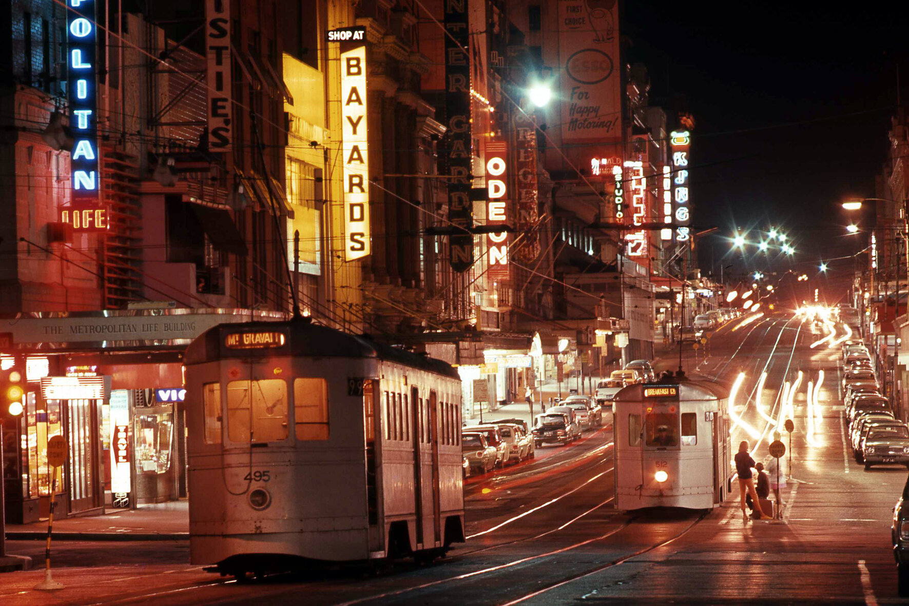 Trams No. 495 and No. 512 on Queen Street from Edward Street lit up with neon signs - 1969