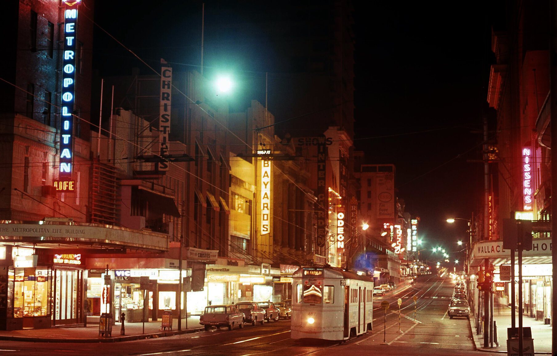Tram No. 487 on Queen Street from Edward Street lit up with neon signs - 1969