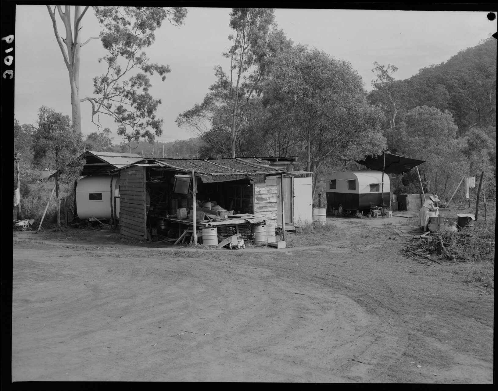 Temporary House, Ashgrove, with caravans and woman washing - 1952