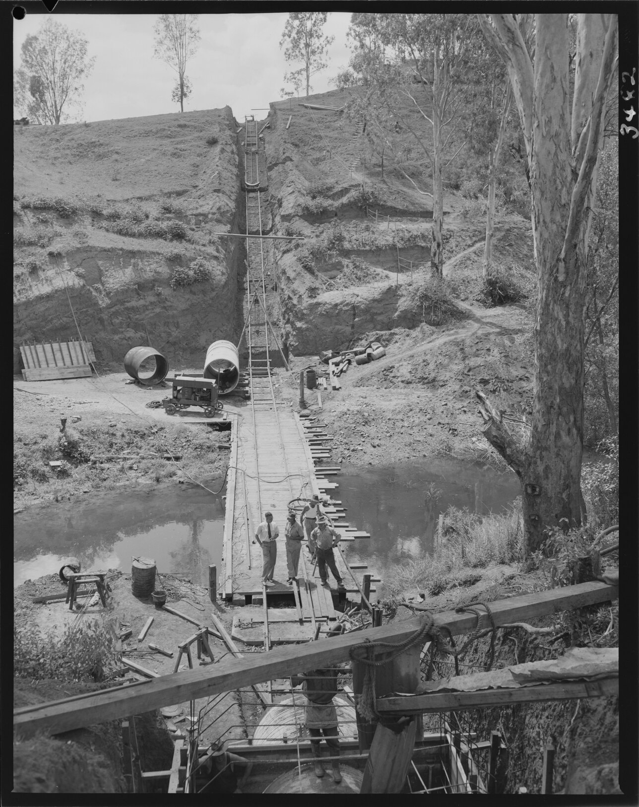 Man laying Ashgrove sewerage main underground -1953