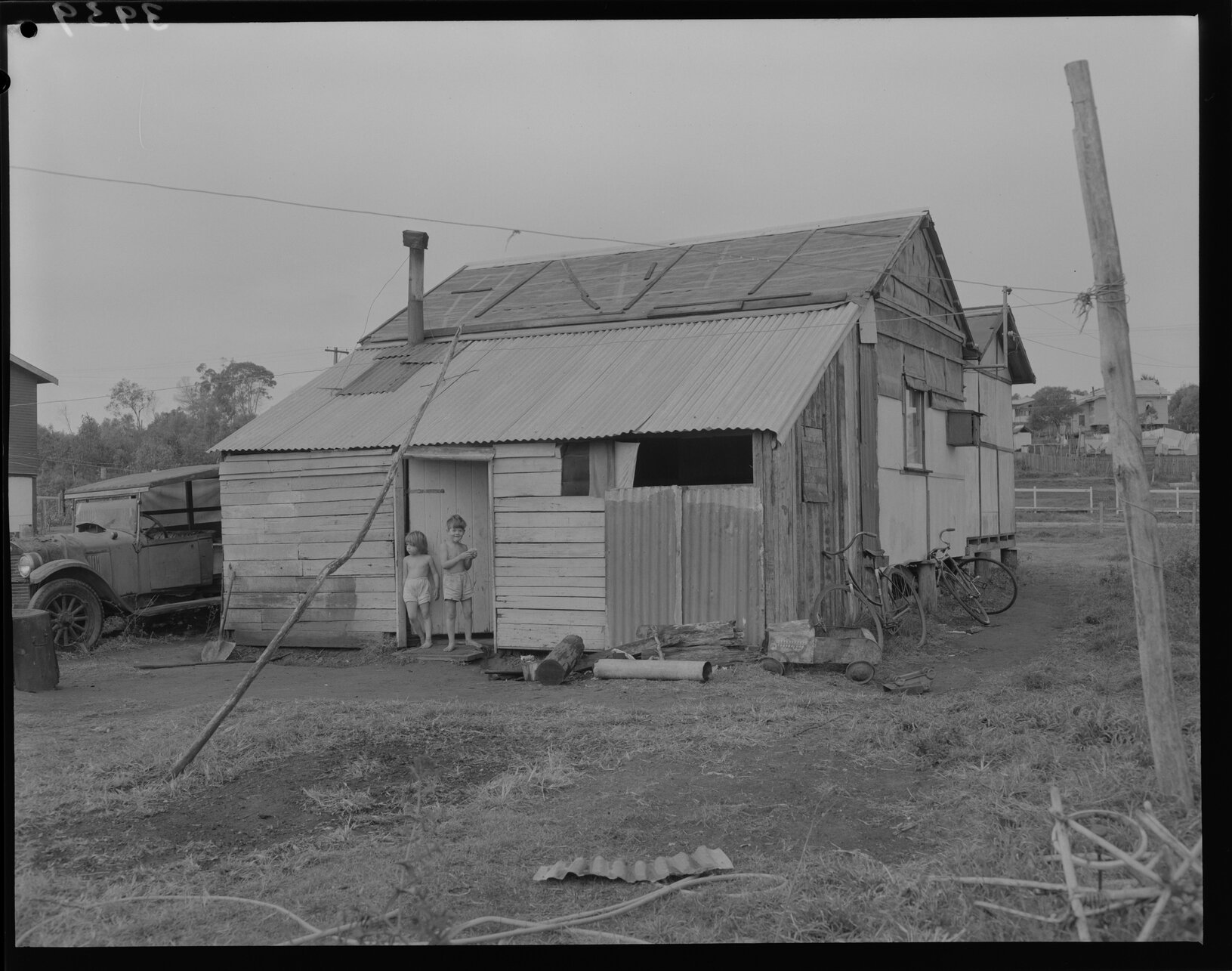 Temporary house with two children in doorway, Lota, Wynnum or Belmont - 1953