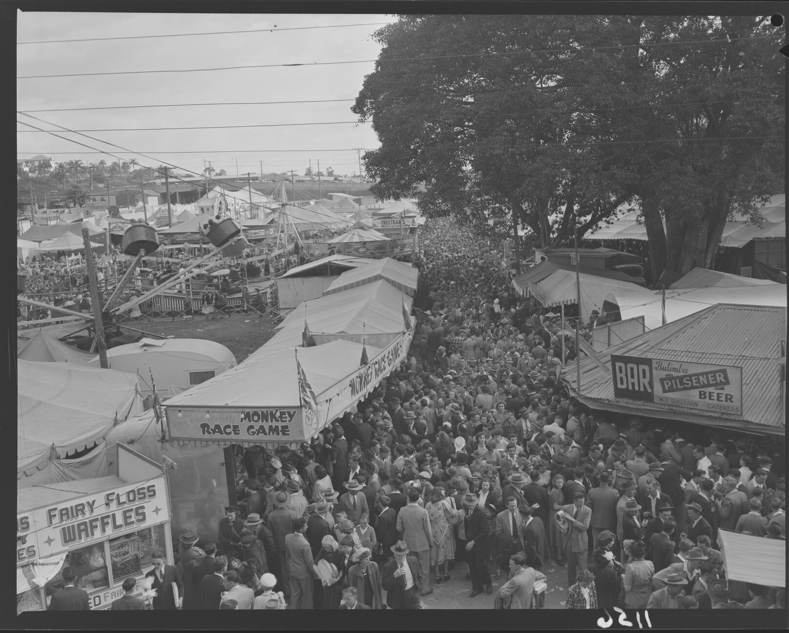 Crowds at rides, games, bar and stalls in Exhibition (Ekka) grounds - 1950