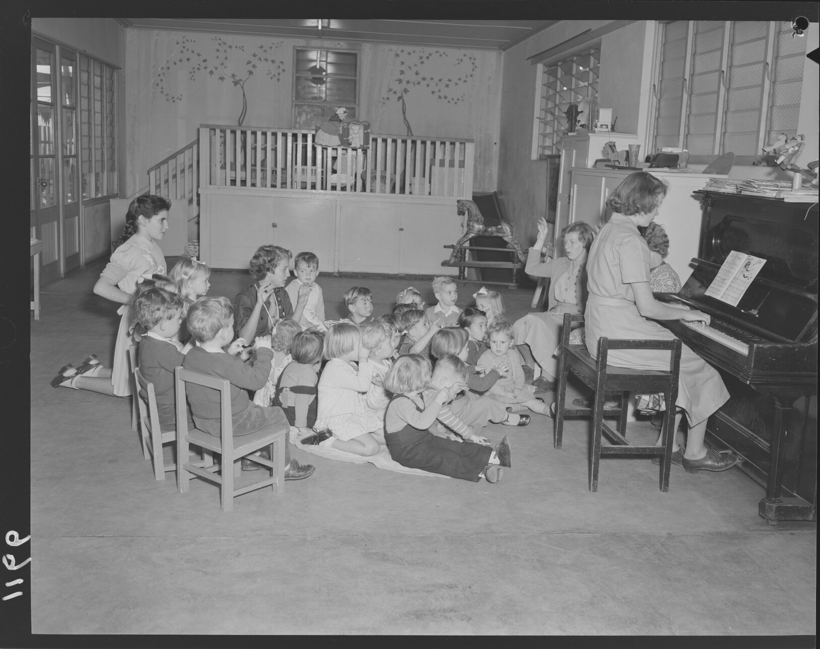 Teachers and children at piano at Kindercraft Civic Nursery (childcare) City Hall - 1950