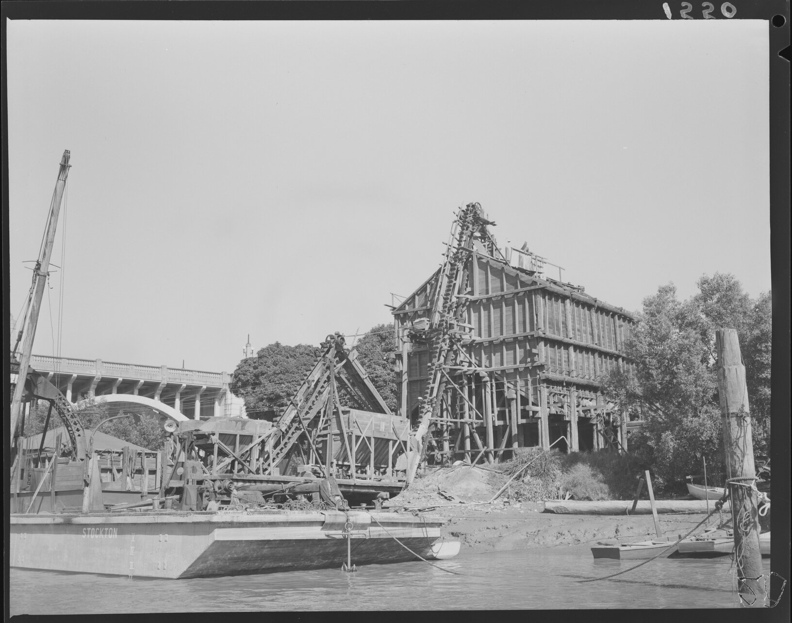 Construction on south river bank with crane barge next to viaducts of William Jolly Bridge, South Brisbane - 1951