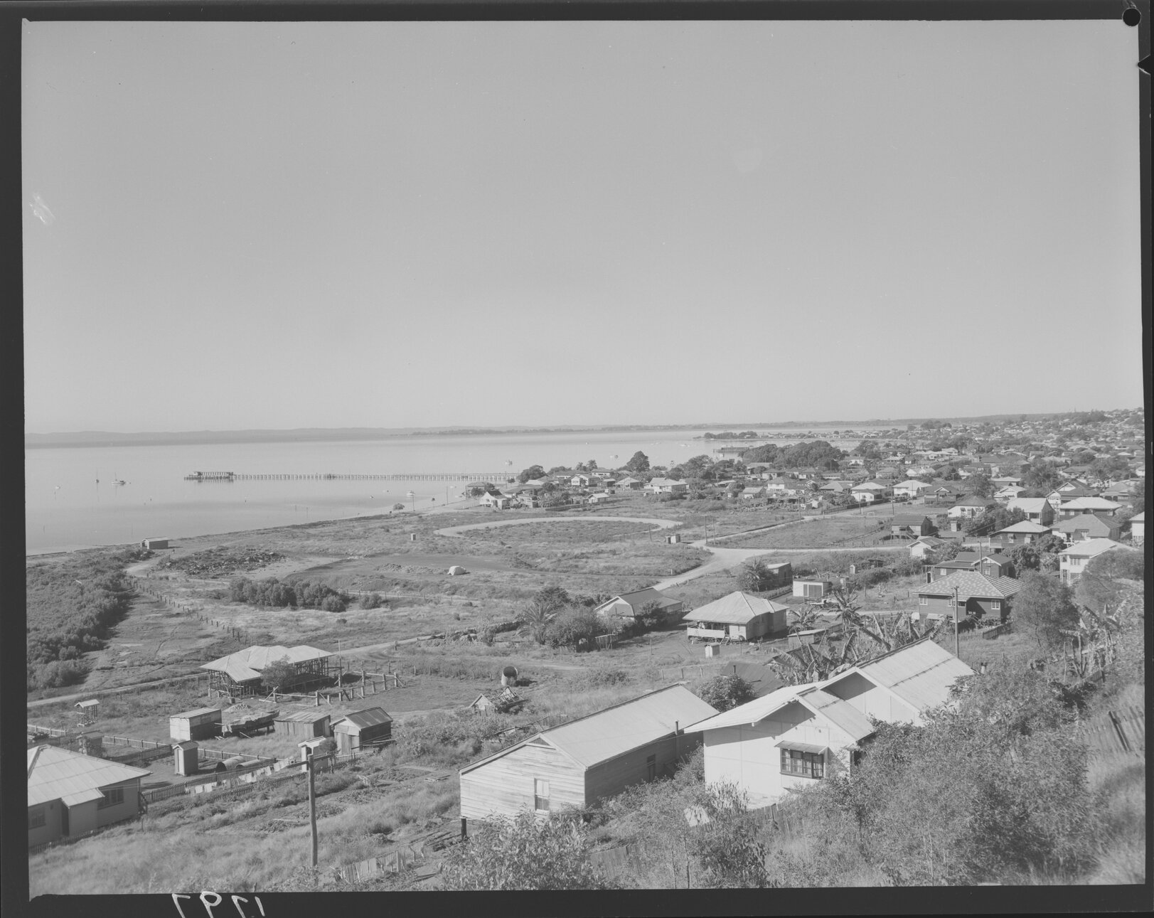 Grassy field with houses at Wynnum looking toward the bay, corner of Granada and Southwick Street in centre right - 1951