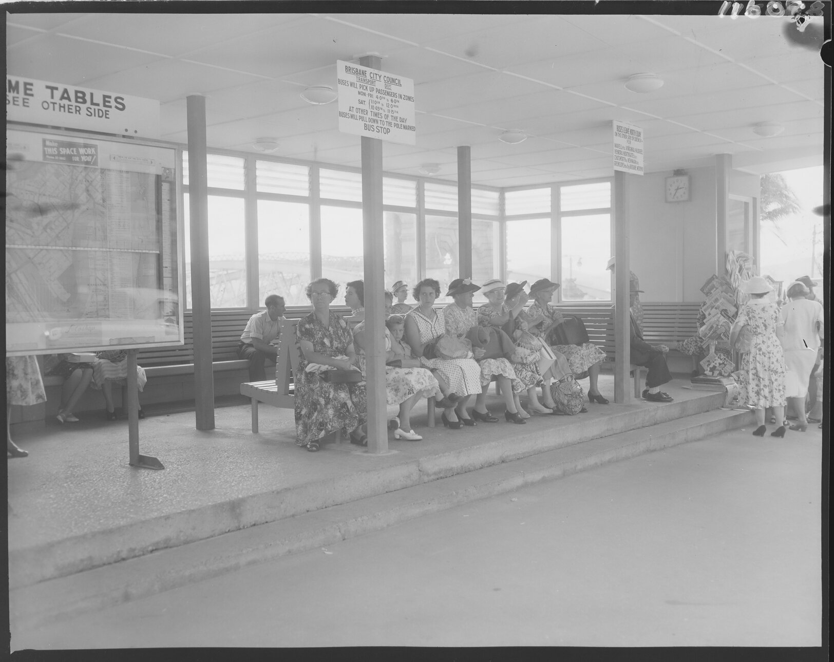 Women waiting at bus shelter, William Street, North Quay, Brisbane City - 1959