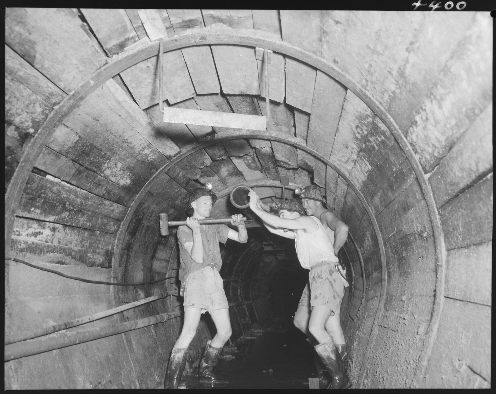 North Kedron Brook sewer concrete framework with three men swinging a hammer - 1953
