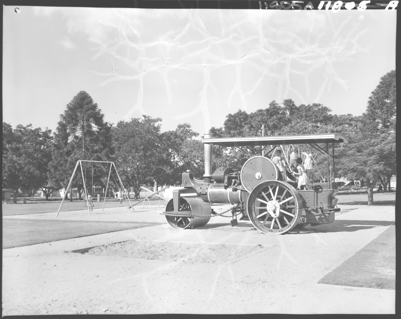Oriel Park playground with children on swings and steamroller, Graceville - 1959