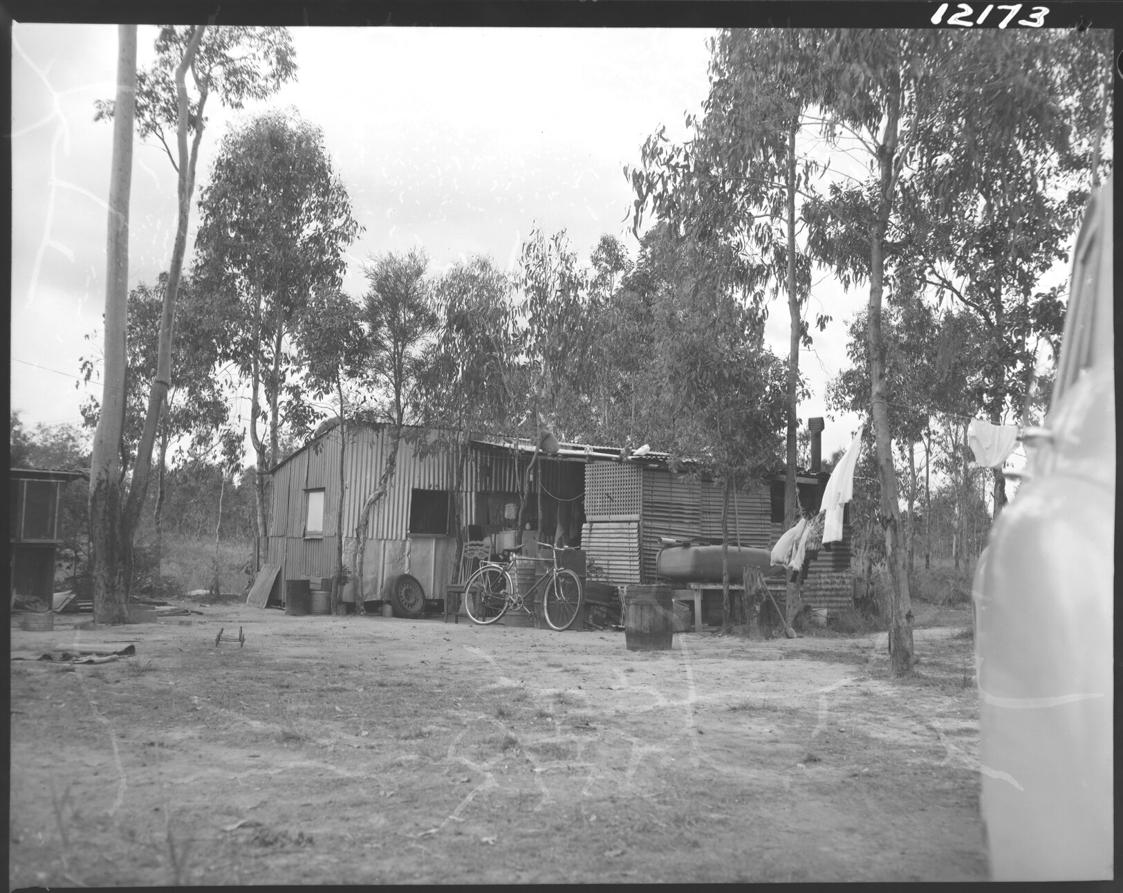 Temporary dwelling with bike and washing line, possibly near Coopers Plains, or near Blunder Road in Oxley, Durack or Inala - 1959
