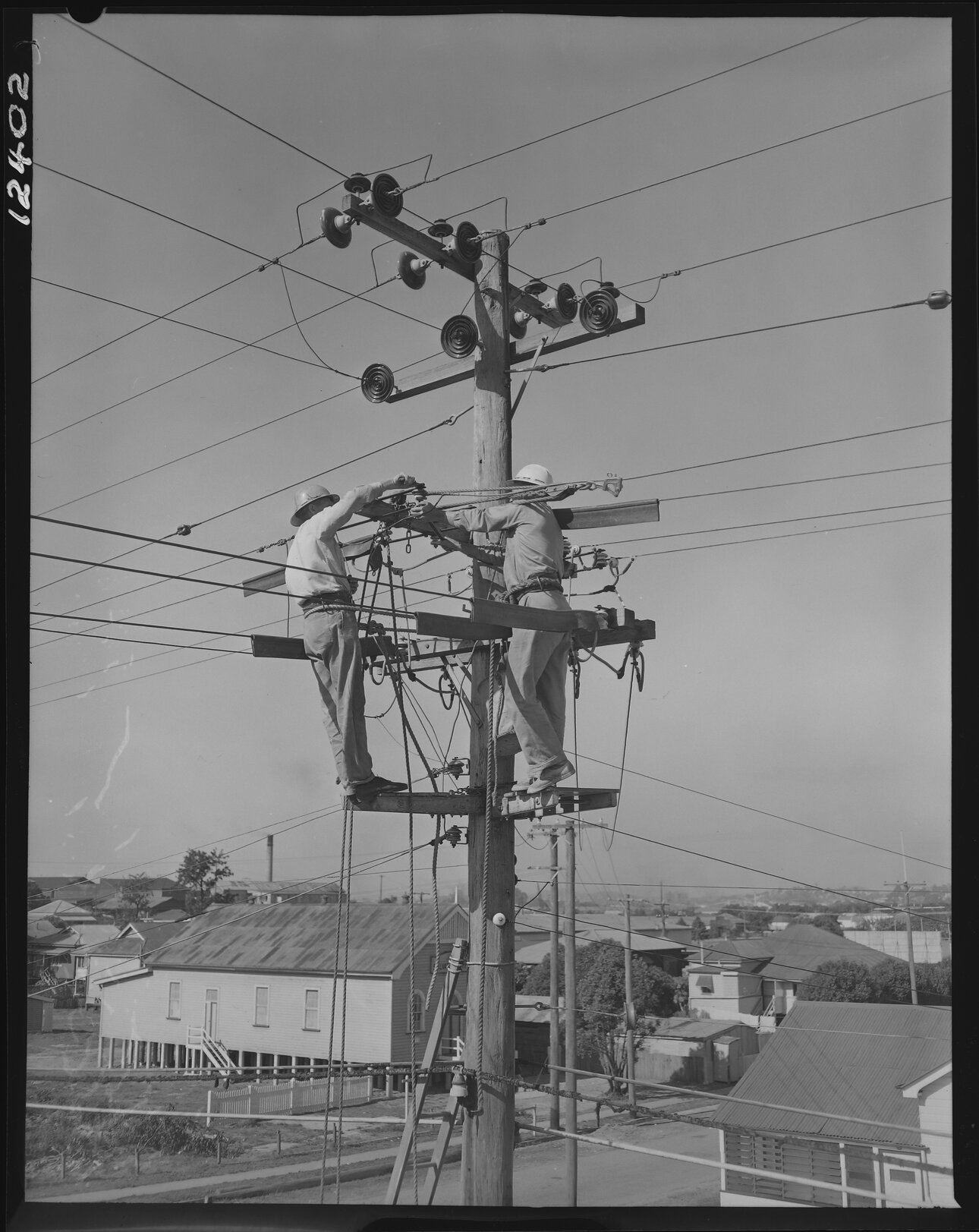 Electricity linesmen demonstrating new safety gear - 1959