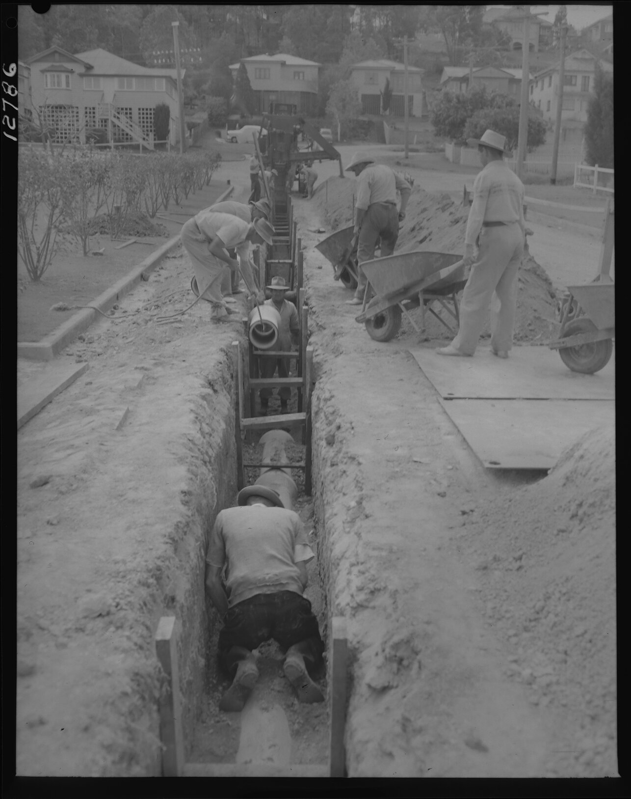 Workmen laying pipe for the Taringa to Tarragindi water main, possibly in Taringa, Tarragindi, Moorooka or Yeronga - 1959
