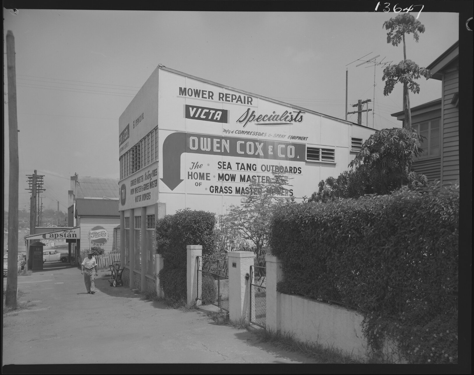 Shops on Ipswich Road, near Wilton Street featuring advertisements for Victa lawn mowers, Woolloongabba - 1960