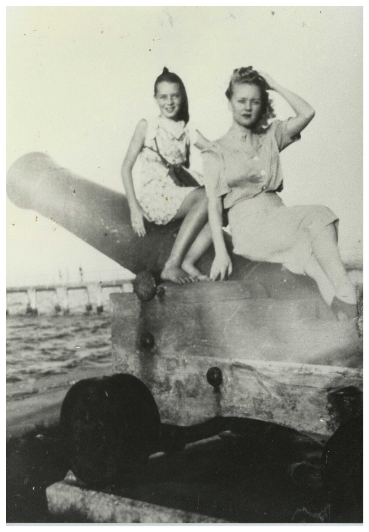 Girl and woman on cannon on Wynnum beachfront, 1930s