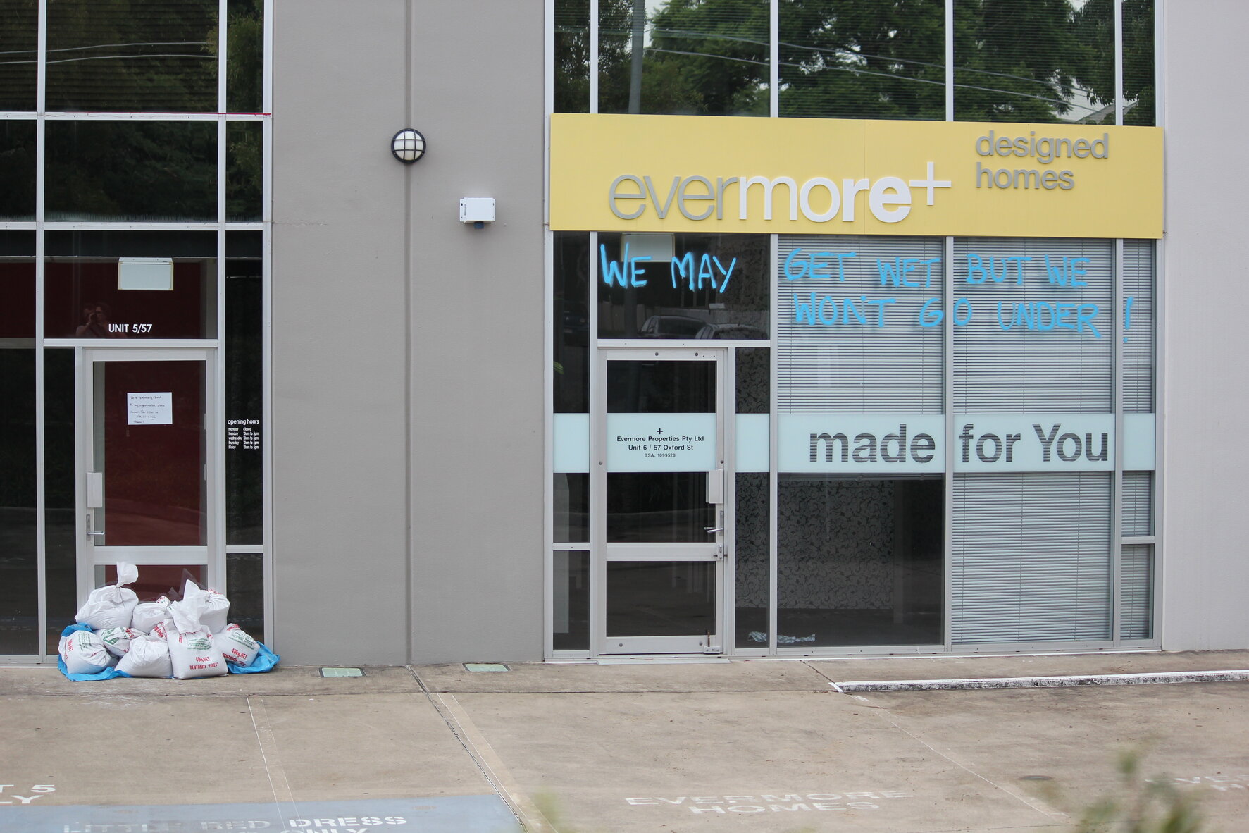Store at Bulimba with spray painted message "We may get wet but we won't go under!" - 2011