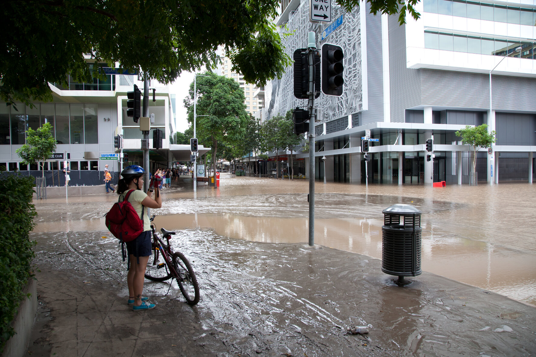 Cyclist taking photo of flooded intersection of Margaret Street and Albert Street, Brisbane City - 2011