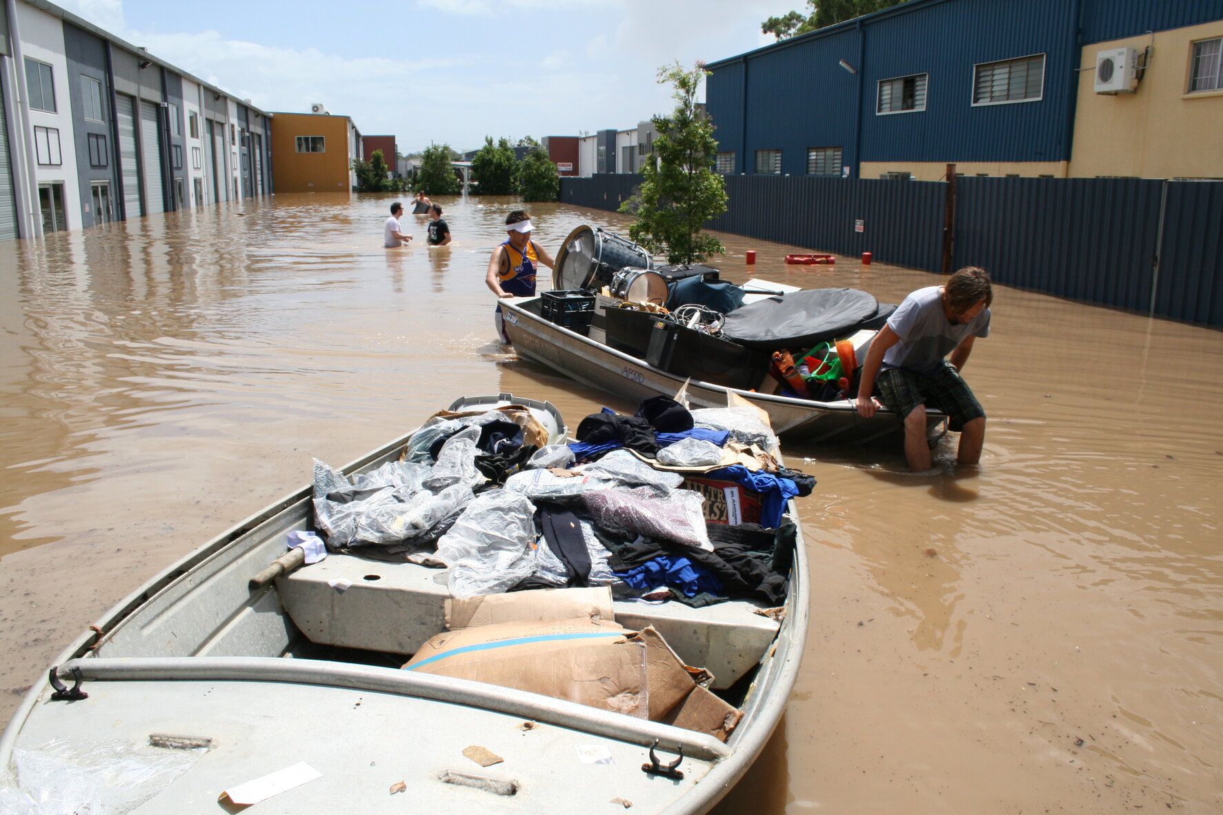 People evacuating their belongings with tinnies through waist high water during 2011 floods, Sumner