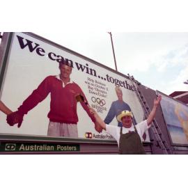 Billy J Smith by a billboard supporting Brisbane's bid for the 1992 Olympics, Fortitude Valley - 1986