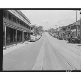 Tramlines and shopfronts, with parked cars, up Wharf Street, Brisbane - 1950