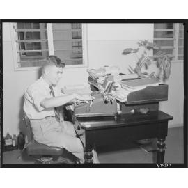 Young man working at City Hall with adding machine - 1950