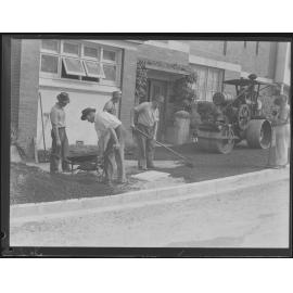 Workers surfacing roads and footpaths with bitumen and steamroller - 1949