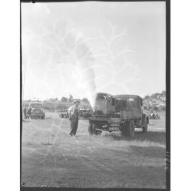 Council worker demonstrating mosquito fogging truck at racecourse, Eagle Farm - 1959