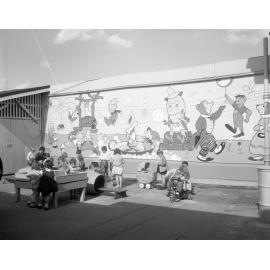 Children playing in front of wall mural, Civic Day Nursery, City Hall, Brisbane City - 1963